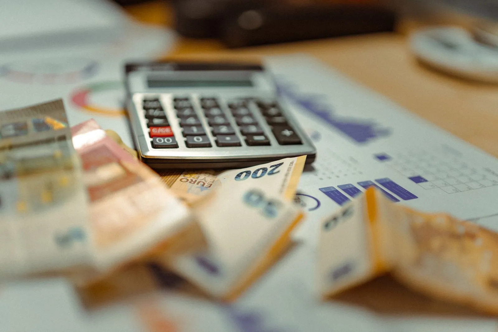 Artisan calculant ses tarifs sur une calculatrice avec devis et carnet de notes sur l'établi.